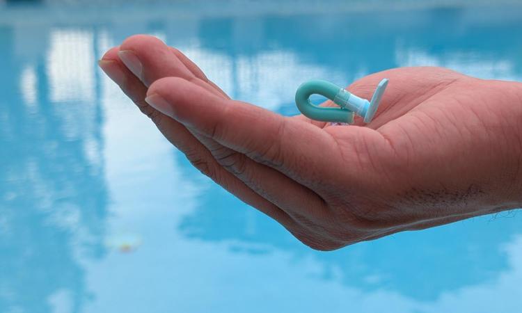 a hand holding a tiny soft robot